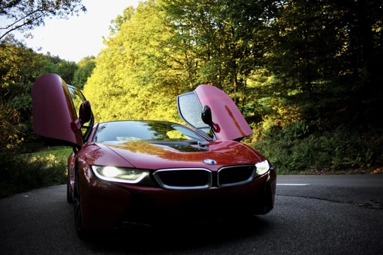 Red sports car with open gullwing doors on forest road red-sports-car-with-open-gullwing-doors-on-forest-road