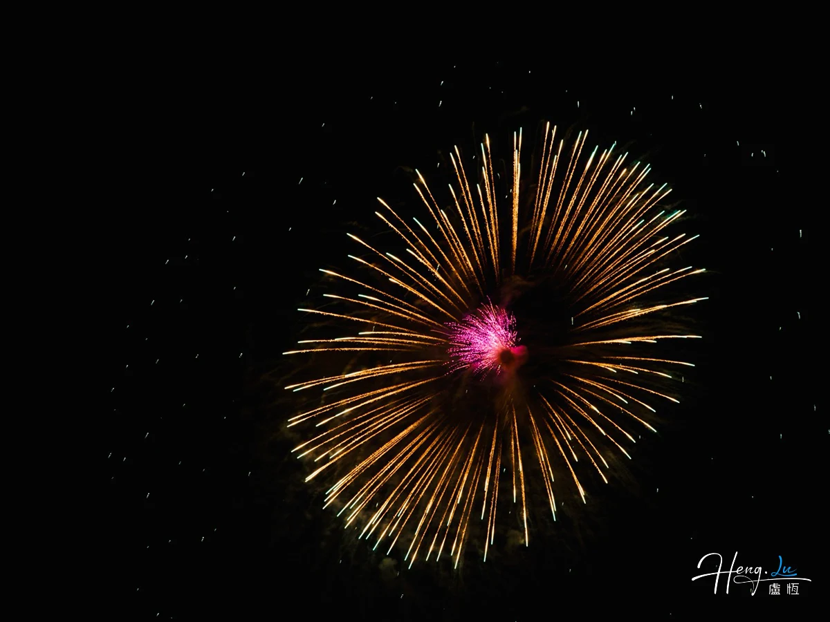 Golden firework bursting in night sky with bright colours