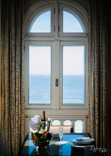 Elegant-window-view-overlooking-ocean-with-fruits-and-champagne